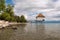 Green beach with Wooden boathouse on Lake Weissensee, Carinthia, Austria under cloudy sky