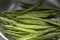 Green beans washed in a metal colander strainer