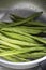 Green beans washed in a metal colander strainer