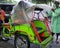 Green becak/rickshaw, a bicicle transport three wheeler with its chauffeur