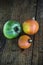 Green beef tomato and red kuri sashes on a dark wooden table