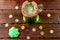 Green beer in a glass mug with gingerbread clover, horseshoe and gold coins on a rustic wooden surface. Festive background for St