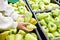 Green bell pepper in hands of customer in store