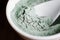 Green bentonite clay powder in a bowl. Diy facial mask and body wrap recipe. Natural beauty treatment and spa.