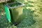 Green bin container filled with garden waste. Spring clean up in the garden. Recycling garbage for a better environment
