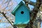 Green birdhouse in a tree