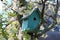 Green birdhouse in a tree
