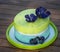 Green birthday cake with blue edible flowers