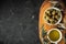 Green and black olives in white bowls on the wooden board and leaves on a black background. Traditional Greek and Italian food.