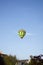 Green, Black, and Yellow Hot Air Balloons flying overhead at Ashland Balloonfest