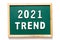 Green blackboard and wood frame with word 2021 trend on white background