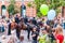 Green blue balloons on foreground and armed mounted police forces riding at the end of Pride parade on Gedimino street on the