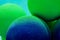 Green and blue balls balloons on cloud sky background. Macro close up image. Vivid holiday poster with copy space. Sunny happy day