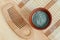 Green blue bentonite clay powder in the bowl and wooden hair brush. Clay texture close up. Diy facial or hair mask