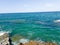 Green and blue sea with rocks