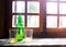 Green bottle of natural Cider with two traditional glasses window still life. Asturias, Northern Spain.