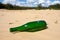Green bottle in sands
