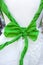 Green bow tied in white doll