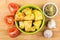 Green bowl with baked potato, spices, garlic and tomatoes