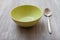 Green bowl and spoon on gray brown table