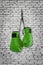 Green boxing gloves hanging on wall