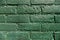 A green brick wall painted