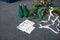 Green bridal shoes, rich green wedding bouquet with pink ribbons and a wedding complimentary lying on a grey floor