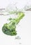 Green broccoli falling in water with air bubbles