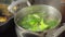 Green broccoli florets simmer and steam up the screen, showcasing a simple yet essential cooking.