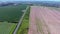 Green and brown fields in british countryside from above via drone