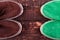 Green and brown suede espadrille shoes on wooden background.