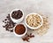 Green and brown unroasted and dark roasted coffee beans in white bowls