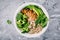 Green buddha bowl lunch with grilled chicken and quinoa, spinach, avocado, broccoli and white beans