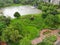 Green bush circular composition with pointed statue in the middle.