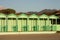 Green cabins in a neat, geometric row. Italian bathhouse in Tuscany on the beach by the sea