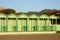 Green cabins in a neat, geometric row. Italian bathhouse in Tuscany on the beach by the sea