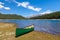 Green Canoe on the shore of a mountain lake