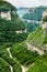 Green canyon with forest and river on the bottom. Foggy clouds behind the rocks. Panoramic view