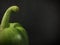 Green capsicum on black background.