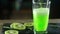 Green carbonated drink is poured into a clear glass glass.