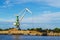 Green cargo crane in terminal in river ship port in Ventspils, Latvia, Baltic sea.