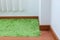 Green carpet covering on laminate wooden floor