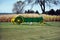 Green cart in front of hay stalks