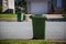 Green cart pickup on curb side. Recycling green garbage carts set outside of the homes on the curb for recycling pickup.