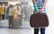 green cast on hand and arm with suitcase isolated on blurred traveler and bag waiting in subway, insurance travel concept