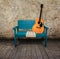 Green chair and acoustic guitar in a grunge room