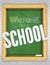 Green chalkboard on a brick wall welcomes children to school with bright lively color chalk letters as a banner poster