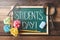 Green chalkboard with handwritten STUDENT`S DAY word on wooden table