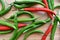 Green chillies and red chillies on a bamboo chopping board.