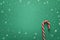 Green Christmas background with red candy canes. Copy space for text.